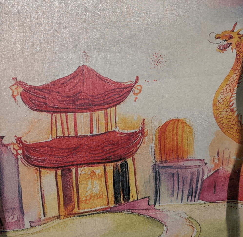 Close-up of the soft Pima cotton fabric of the Lunar Lanterns Story Scarf, showing the dragon illustration.